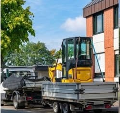 Compact excavator loaded on a trailer ready for delivery